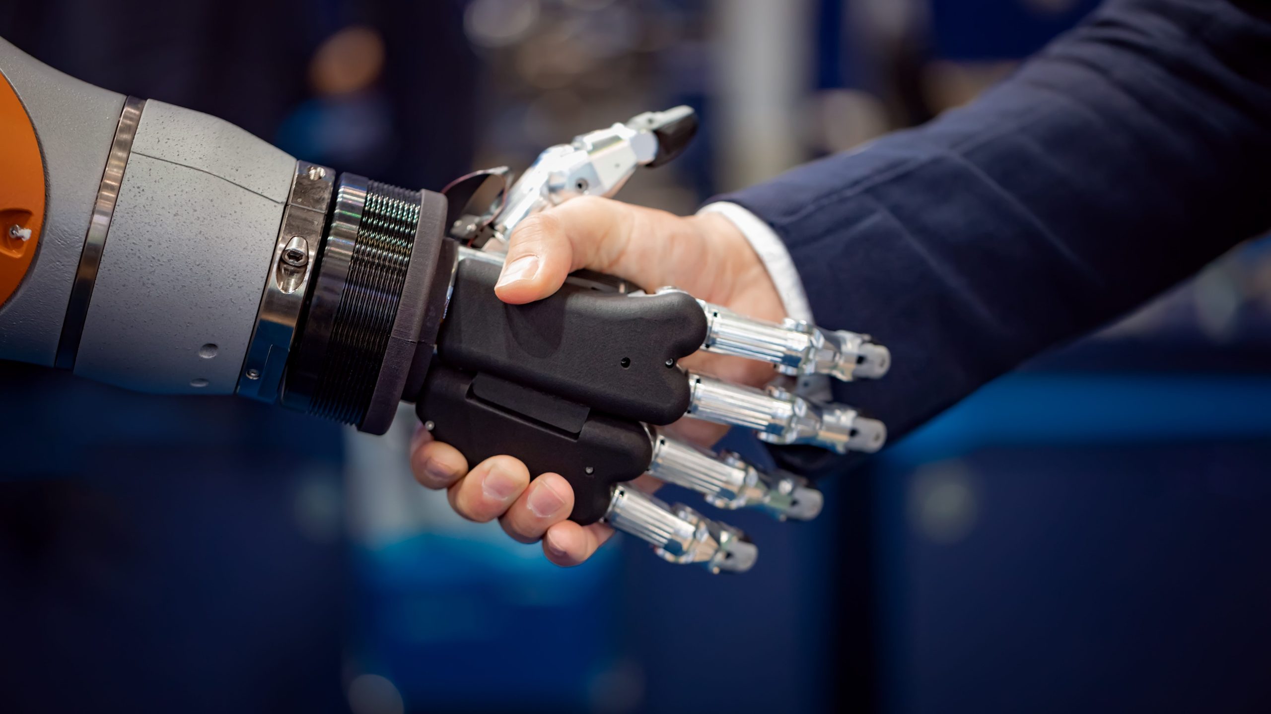 Hand of a businessman shaking hands with a robot.